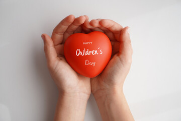 Happy Children's Day. A child's hands holding a heart with the text written on it.