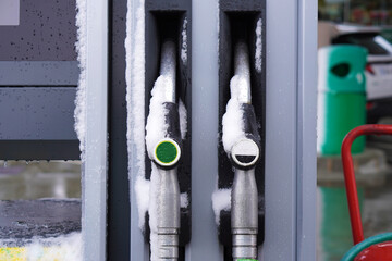 gasoline and diesel pumps covered in snow at a gas station