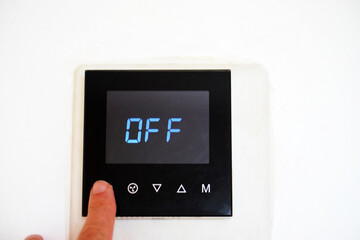 person turning off the digital display on the heating system