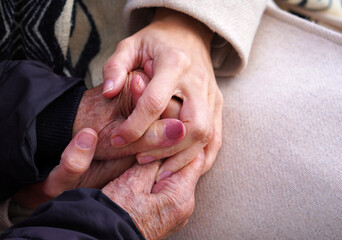 Grandmother and granddaughter's hands intertwined in a gesture of love and protection