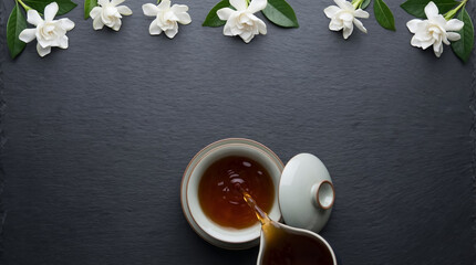 Dark slate Qingming festival background with elegant copyspace background and tea pouring ceremony. Minimal spring design background with space for text