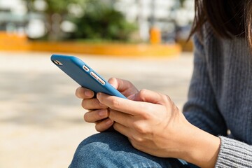 Woman Using Smartphone Outdoors in Casual Attire