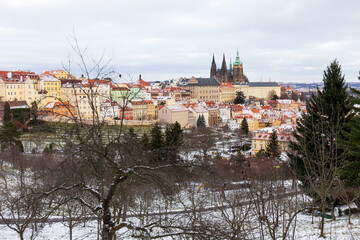 Obraz premium Snowy Prague Lesser Town with gothic Castle from Hill Petrin, Czech Republic 