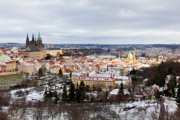 Obraz premium Snowy Prague Lesser Town with gothic Castle from Hill Petrin, Czech Republic 