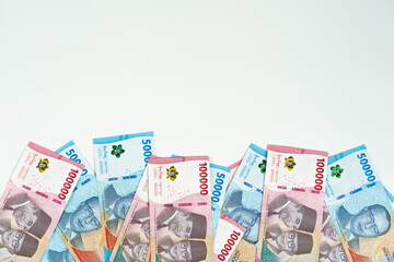 Indonesian rupiah banknotes of 10000 and 50000 denominations on white background with copy space,...