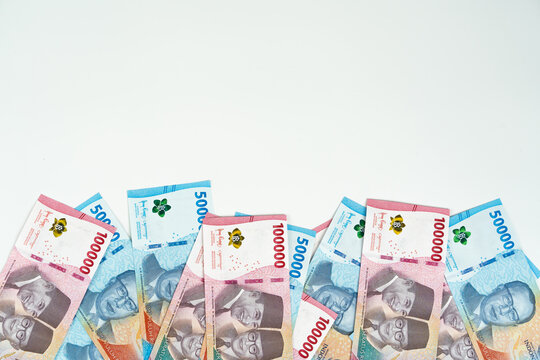 Indonesian rupiah banknotes of 10000 and 50000 denominations on white background with copy space, finance and money concept for savings, business, and economy