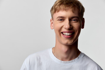 Smiling man in a white shirt in a bright studio, conveying friendly energy, approachability, and...
