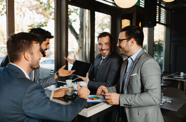 Businessman showing a presentation on a digital tablet to his colleagues during a meeting