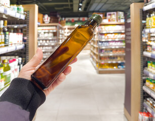 choosing olive oil, sauce, vinegar at the grocery store