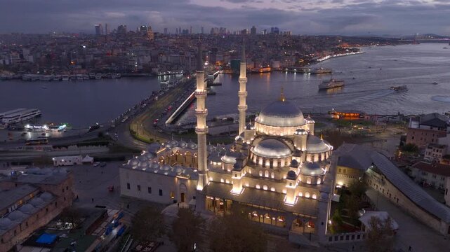 Aerial drone view of Istanbul historic Golden Horn, showing the Eminonu New Mosque or Yeni Cami, Galata Bridge, and Bosphorus at sunrise or sunset. Topkapi Palace and Hagia Sophia in the distance.