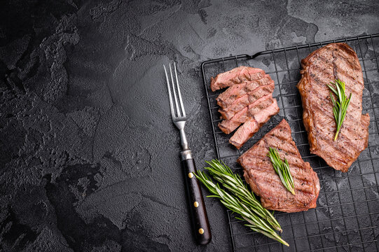 Grilled Top blade steak, shoulder beef meat. black background. top view