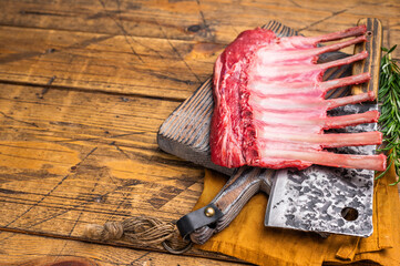 Butcher board with Raw lamb meat for chops steaks, fresh rack of mutton. wooden background. top view