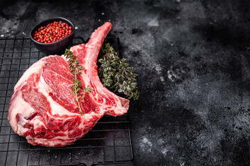 Uncooked tomahawk steak, raw black angus beef rib eye with bone. black background. top view © Mironov