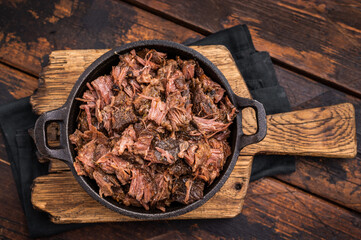 Traditional Barbecue smoked beef meat, pulled beef in a skillet. wooden background. top view © Mironov