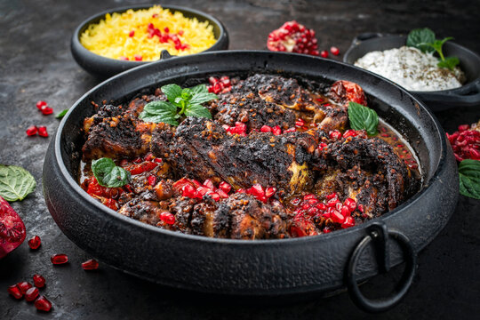 Traditional authentic Persian khoresh fesenjan - chicken stew with walnut and pomegranate sauce, saffron basmati rice and mast o khiar - mint yogurt dip