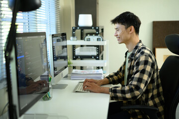 A Man IT Specialist in home office workplace with coding language program on computer