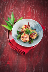 Homemade vegan bread knodel dumpling with beetroot and fresh buttered caramelized sage served as close-up on a design plate