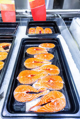 Steaks of fresh salmon fish on the counter. Raw red fish for sale. Seafood shop