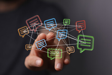 Abstract conceptual image featuring a hand interacting with digital message bubbles. Represents communication, technology, and interconnectednes