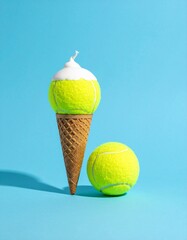 A minimalist concept with two tennis balls and one ice cream cone topped with a swirl of cream, set against a vibrant blue background, evoking a fun and playful mood. Creative design and content.