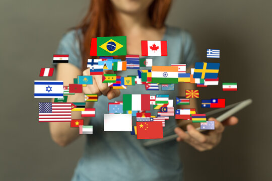 Diverse flags of the world representing international connections, technology, and global unity concept. Hand holding a tablet. Flags from vario