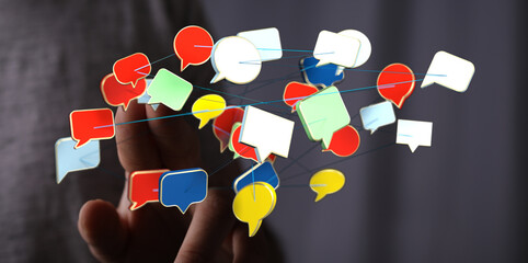Hand holding interconnected speech bubbles representing online communication, social media, and information sha