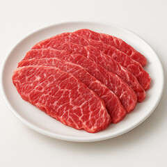 Fresh raw beef steak and uncooked red meat slices served as a fresh cooking ingredient on a white plate isolated for a gourmet dinner meal