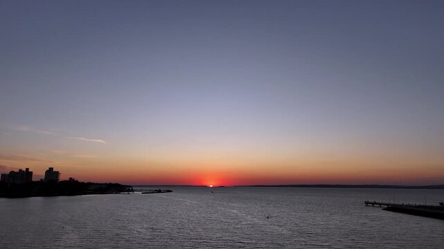 Golden sunset over the Parana River and Posadas costanera. Stunning orange sky and river view in Misiones, Argentina.