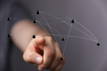 Hand touching digital network nodes representing connections. Ideal for concepts like connectivity and communic