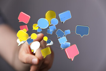 Hand holding interconnected colorful speech bubbles representing communication, social media, and network