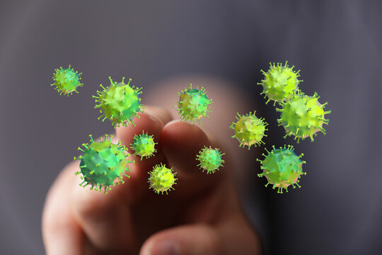 Conceptual image of a hand interacting with virus particles. Represents the spread of disease, concept of coro