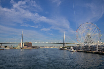 Obraz premium Sailing Through Osaka Bay with Bridges and Ferris Wheel