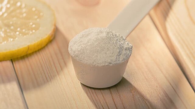 Close-up of a supplement scoop and lemon slice on wood, ideal for promoting sport supplements, nutrition, and healthy lifestyle in commercial video content, featuring bcaa, featuring Glucosamine, feat