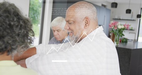 Pointing bearded man wearing white shirt reviewing line graph overlay in kitchen, with flowers