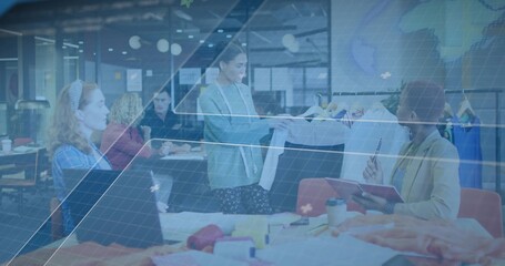Presenting center designer in blazer holding fabric sample at studio, showing swatches and racks