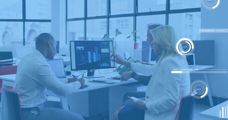 Reviewing trio in business attire pointing at monitor and noting at office desk UI overlay