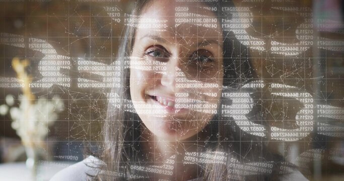 Smiling middle-aged woman wearing light top gazing at camera at home with data overlay showing code - Powered by Adobe