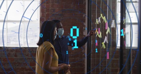 Pointing man explaining at loft glass board, masked woman in yellow top holding post-its AR overlay