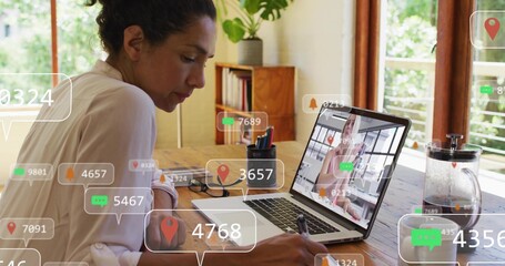 Writing woman in light blouse leaning at home table, using laptop with colleague, pen, overlays