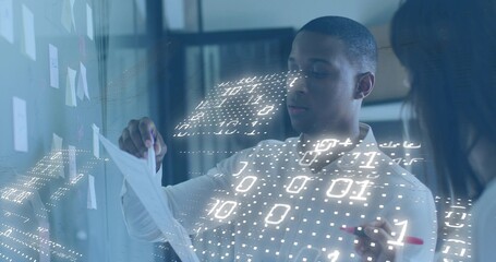 Holding paper, pair pointing at glass wall notes with red marker and hologram, wearing shirts