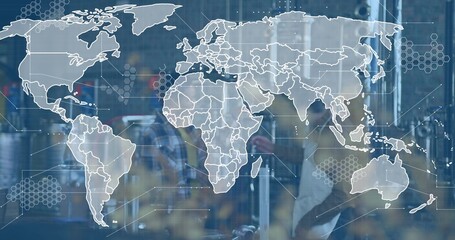 Standing technicians in safety vest inspecting panels through factory glass with world map decal