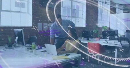 Collaborating team in yellow top and blue shirt leaning over laptop in loft office, purple overlay
