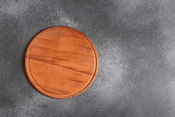 Wooden cutting board close-up on gray background, top view