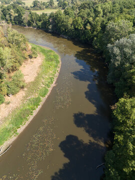 Aerial view of the tranquil oxbow lake of the Morava River meandering through lush greenery, its waters reflecting the sky, Vysoka pri Morave, Bratislava Region, Slovakia.
