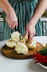 The process of cutting cauliflower in the kitchen