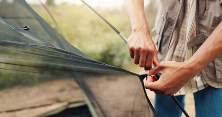 Hands, person and building tent for camping adventure, travel preparation and holiday in wilderness. Man, setup cable or equipment to assemble shelter, pitching skills and vacation safety at campsite