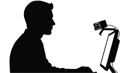 Man sitting at desk with computer and webcam in profile view, working or video conferencing in modern office setting with technology