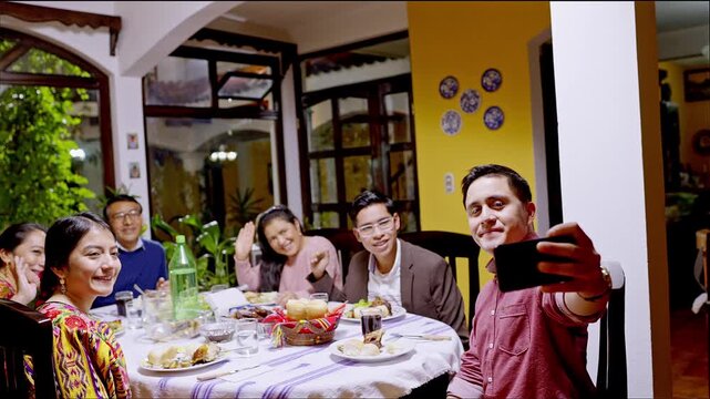 Young man takes a self-portrait of his family during a family celebration.