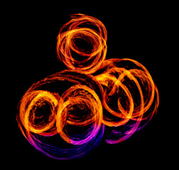 a long-exposure photograph of a fire performance, where a skilled performer spins flaming props like poi to create mesmerizing light trails and intricate patterns against the dark background