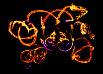 a long-exposure photograph of a fire performance, where a skilled performer spins flaming props like poi to create mesmerizing light trails and intricate patterns against the dark background